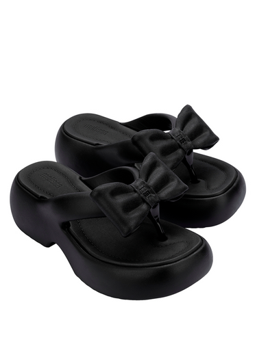A pair of black thick platform sandals with bow detail from Melissa