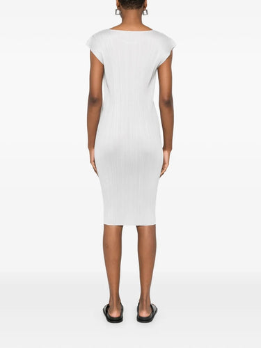 Back view of model wearing the light grey, short sleeves, pleated dress from Pleats Please Issey Miyake on a white background