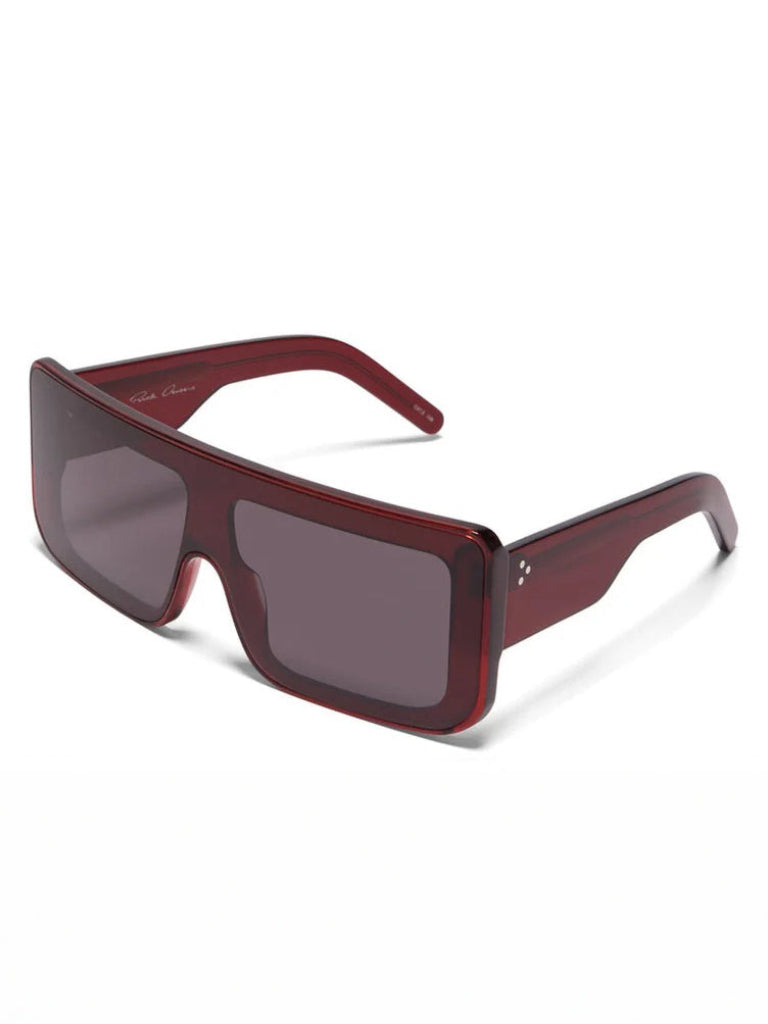 Three-quarter view of Rick Owens Documenta Sunglasses showing blood red acetate frame, wide arms and oversized rectangular silhouette