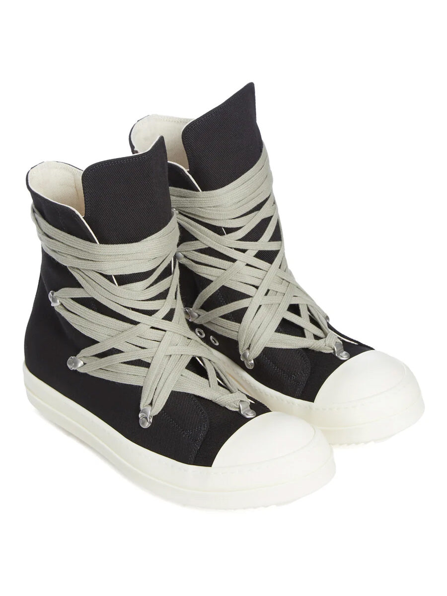 Angled view of Rick Owens DRKSHDW Megalace Sneaks in Black Overdyed Denim with oversized pale grey laces, black denim upper, milk white toe caps and serrated sole