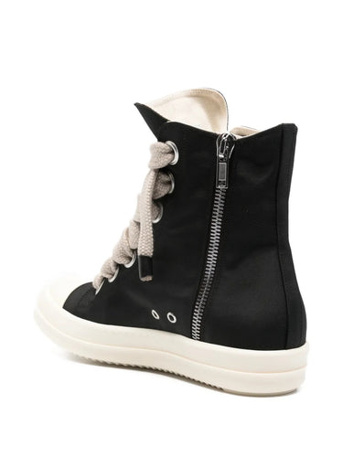 Side view of black high-top sneakers with jumbo laces from Rick Owens on a white background