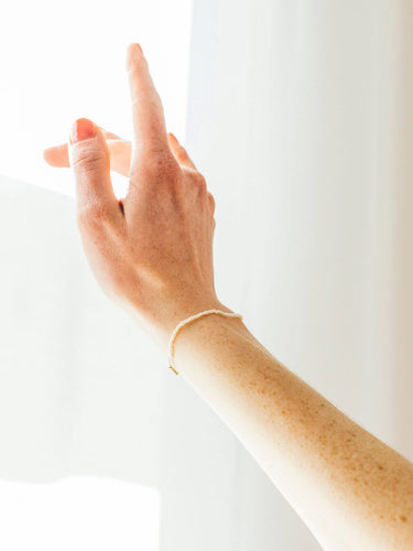 Model wearing the Fine Pearl Bracelet in Gold/Pearl from the Saskia Diez Spring Summer 2026 collection on the hand, highlighting the delicate freshwater pearls and gold clasp.