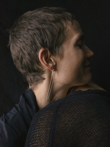 Model wearing the Fringe Mixed Earrings Loop in Silver from the Saskia Diez Spring Summer 2026 collection, highlighting the delicate recycled-silver box chain loops with two different thicknesses.