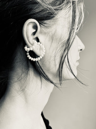 Model wearing the Pearl Earcuff Double in Pearl from the Saskia Diez Spring Summer 2026 collection, highlighting the double pearl detail on the ear.