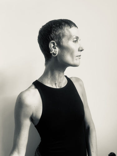 Side view of a model wearing the Pearl Earcuff Double in Pearl from the Saskia Diez Spring Summer 2026 collection, showing the double pearl design hugging the ear.