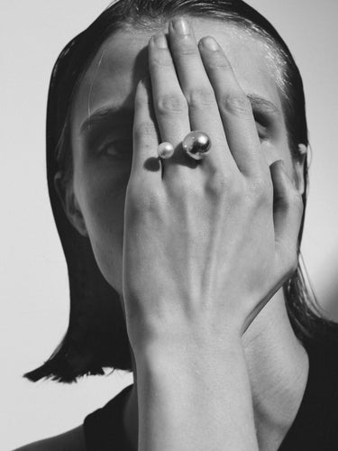 Close-up of a model wearing the Sling Ring No2 in Silver/Pearl from the Saskia Diez Spring Summer 2026 collection, focusing on the adjustable fit and the two spherical elements.