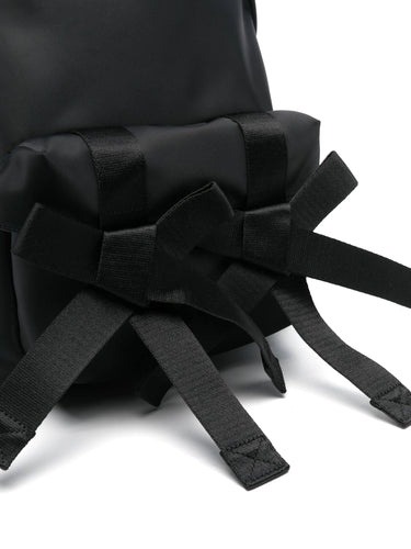 Close-up of a black backpack with multiple straps on a white background