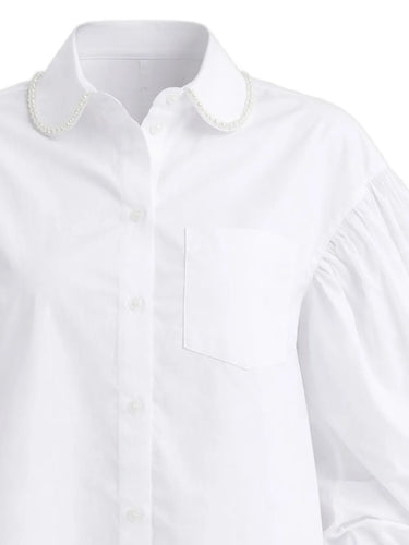 Close-up of the white shirt from Simona Rocha with pearl details on collar