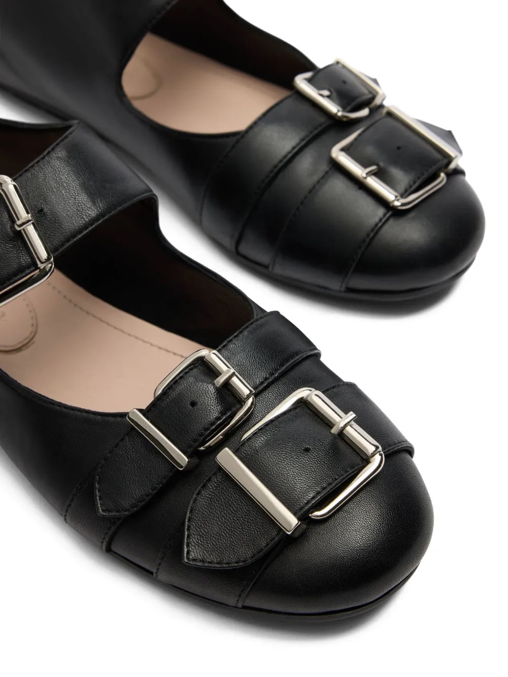 Black leather shoes with silver buckles on a white background