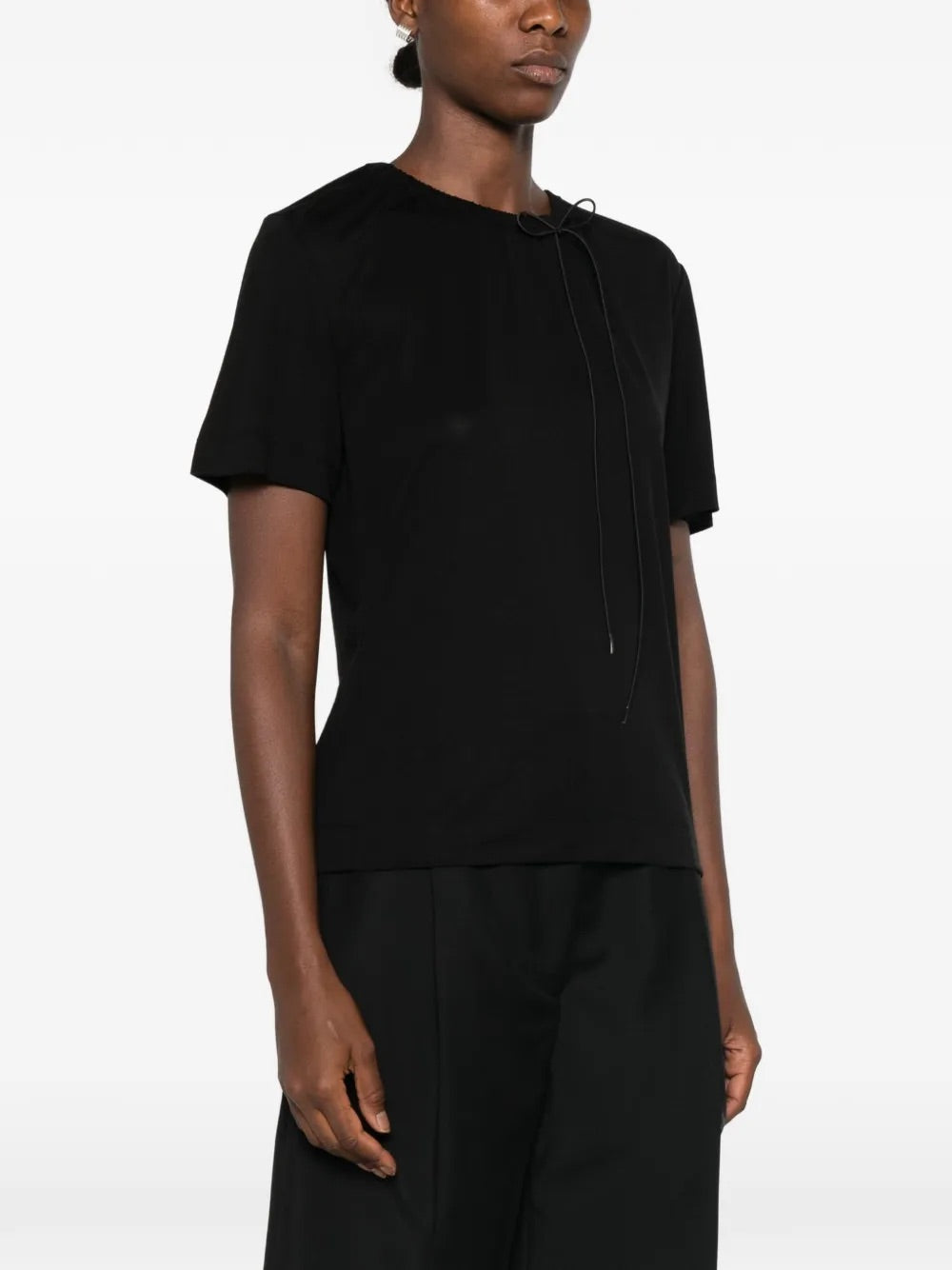 Model wearing Simone Rocha black Cord Neck Easy T-Shirt with delicate bow neckline and relaxed draped silhouette