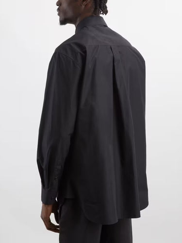 Back view of a man wearing the black shirt with flower frill details from Simone Rocha on a grey background