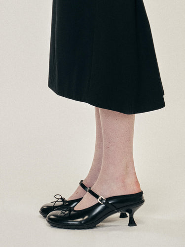 A model wearing the black heeled mules with grip soles from Simone Rocha