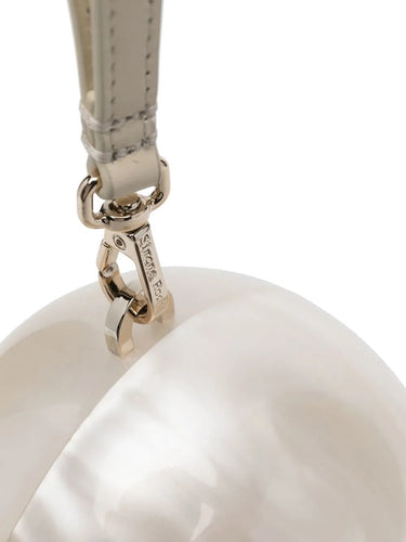 Close-up detail of the Simone Rocha Egg Bag highlighting the faux pearl embellishment and smooth pearl-toned perspex surface.