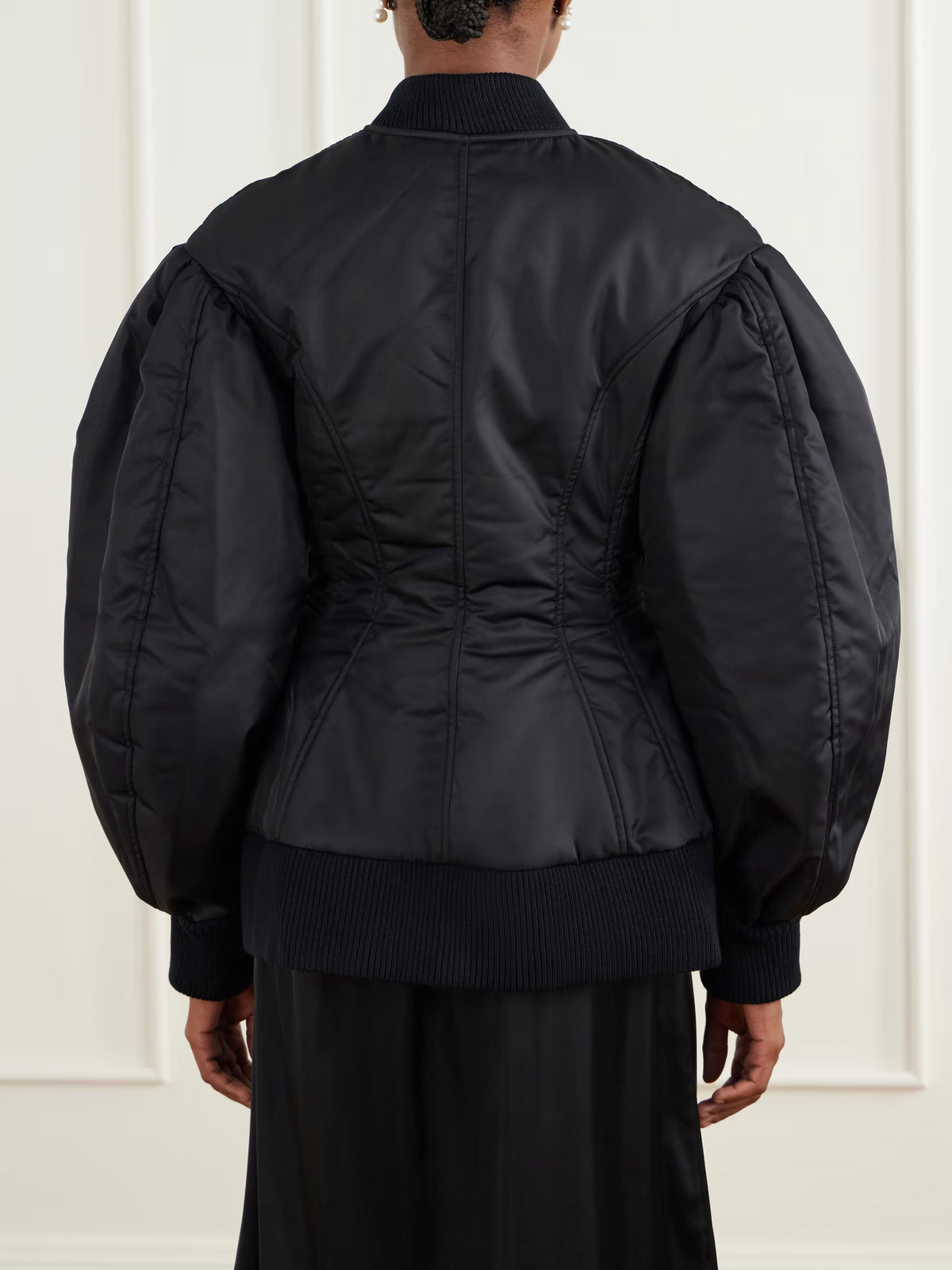 Back view of the Simone Rocha Padded Sculpted Bomber Jacket in Black, showing curved panel seams, voluminous sleeves and ribbed hem.