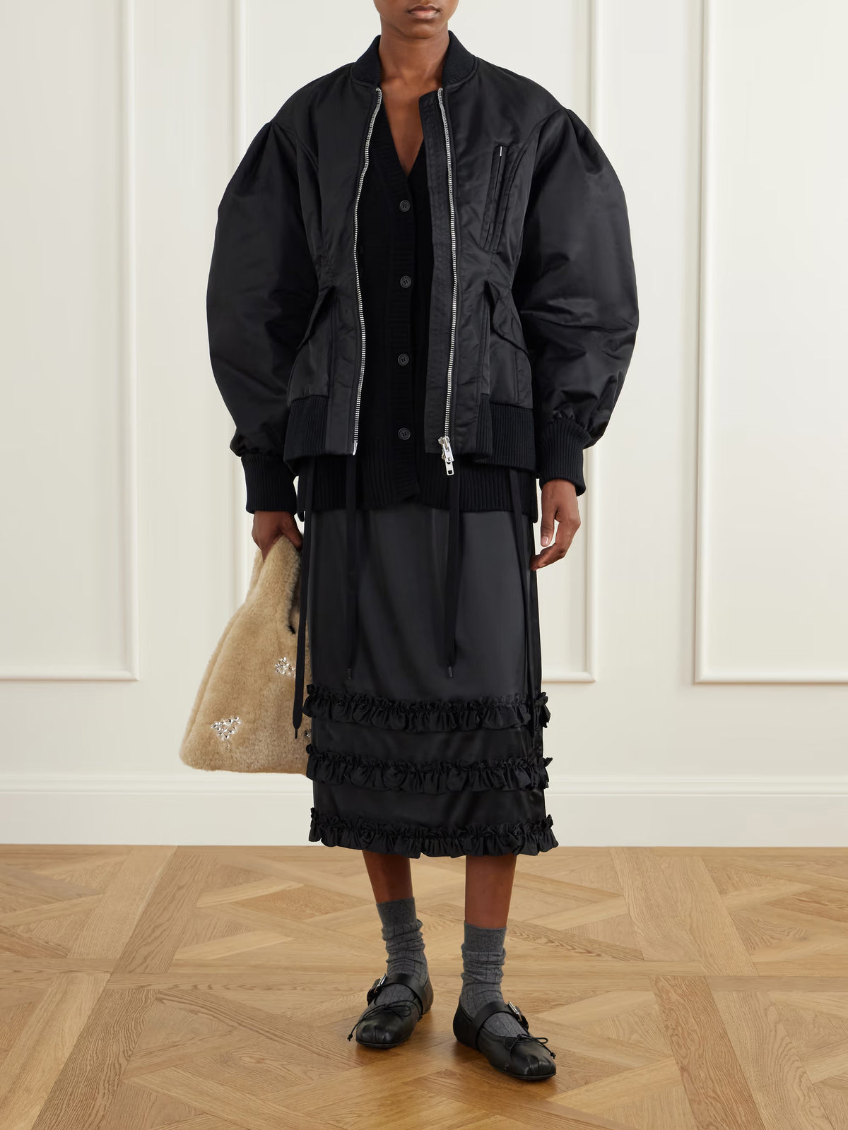 Simone Rocha Padded Sculpted Bomber Jacket in Black styled on a model with a black midi skirt and layered knitwear.