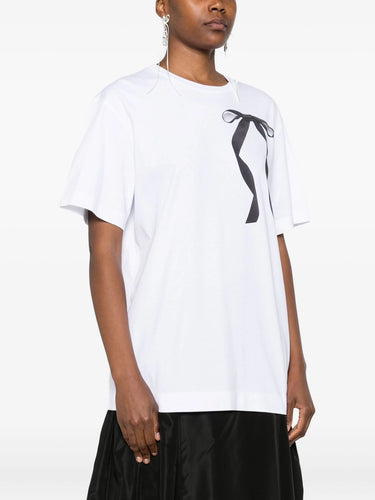 Person wearing a white t-shirt with a black ribbon logo on a white background