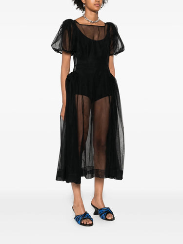 Black sheer dress worn by a model on a white background