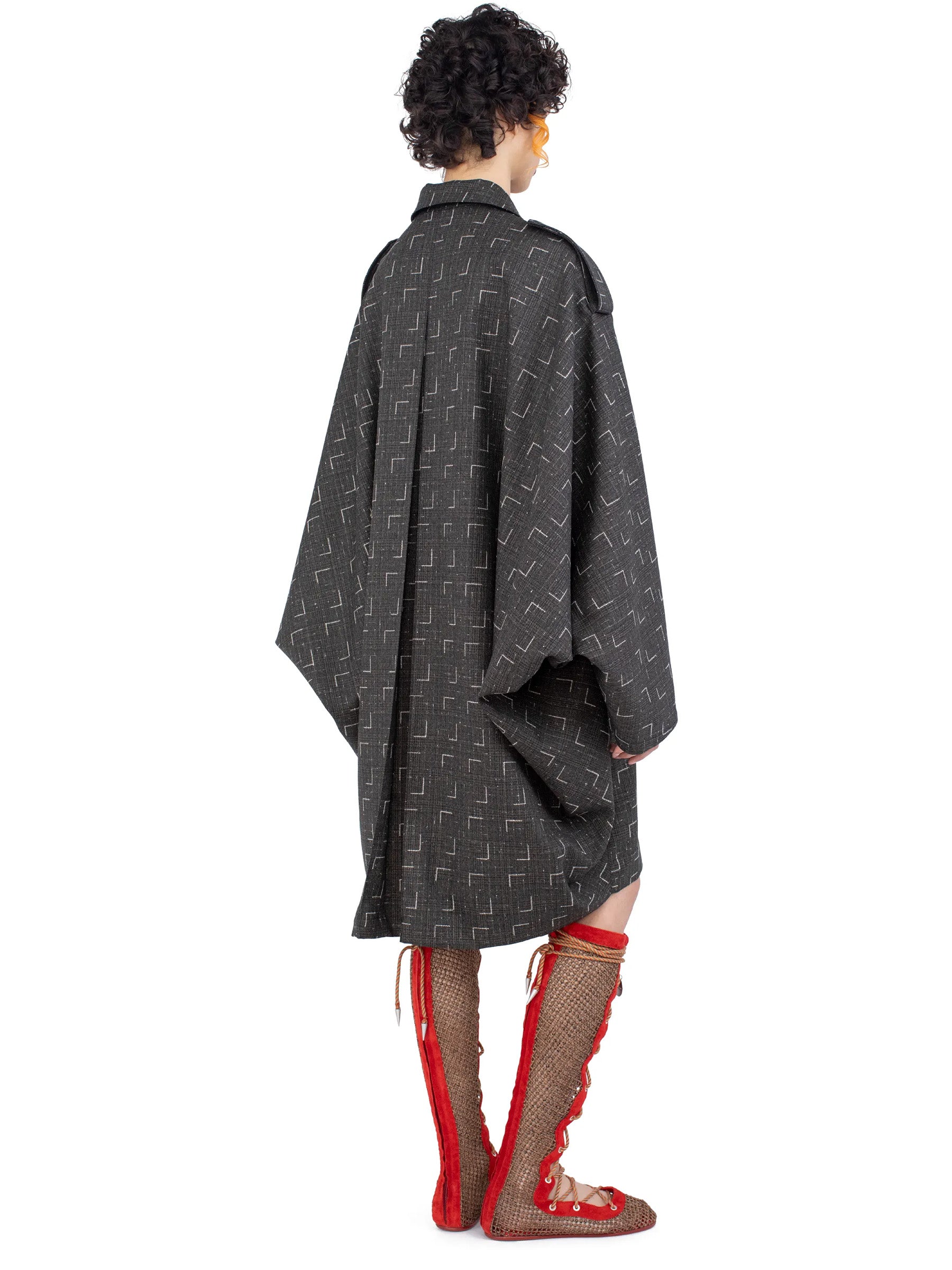 Rear view of the model wearing the Kiko Kostadinov Statsinger Coat in Off Black & Chalk.