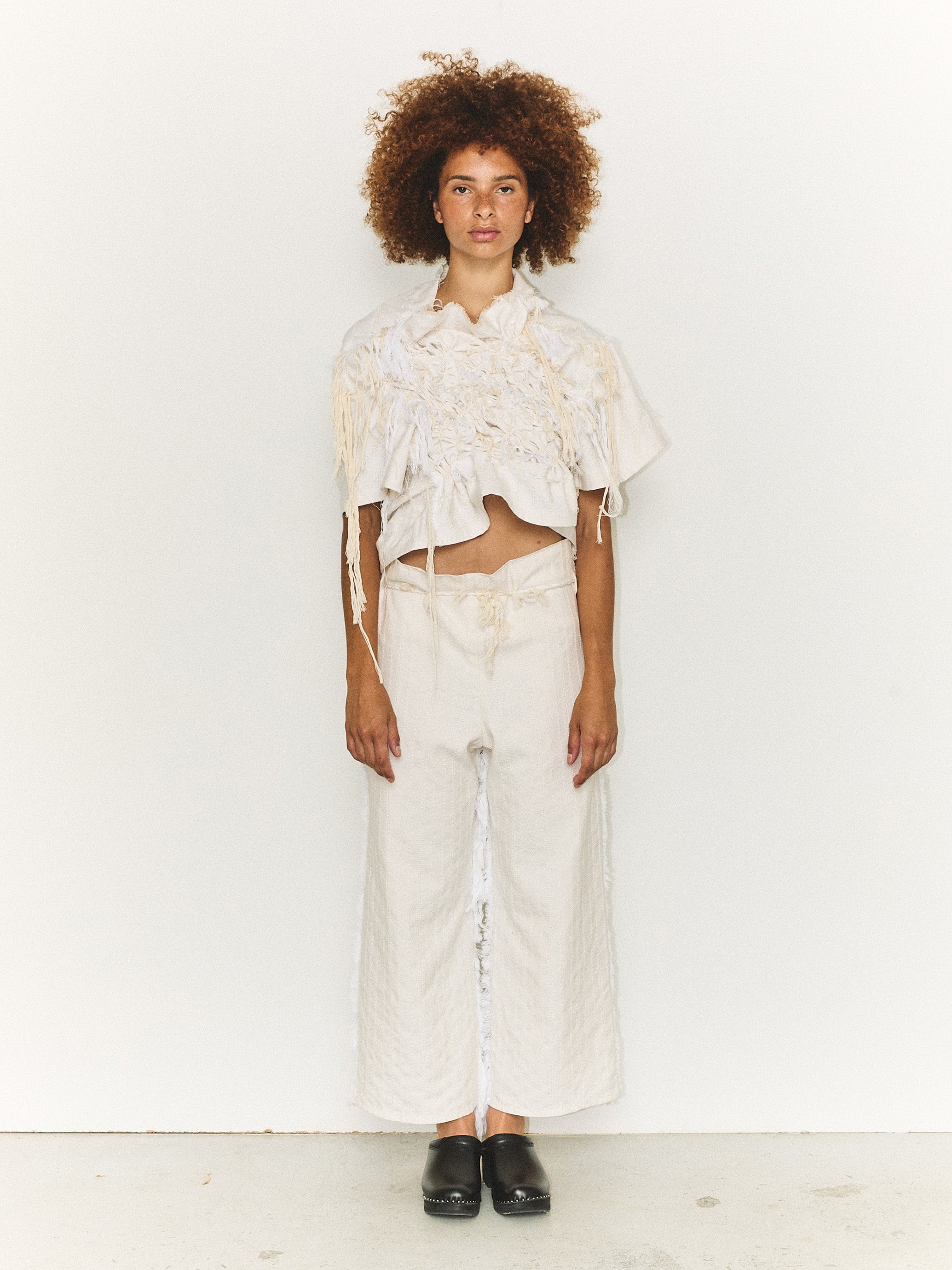Model wearing the Stem Basket Tee in off-white, front view