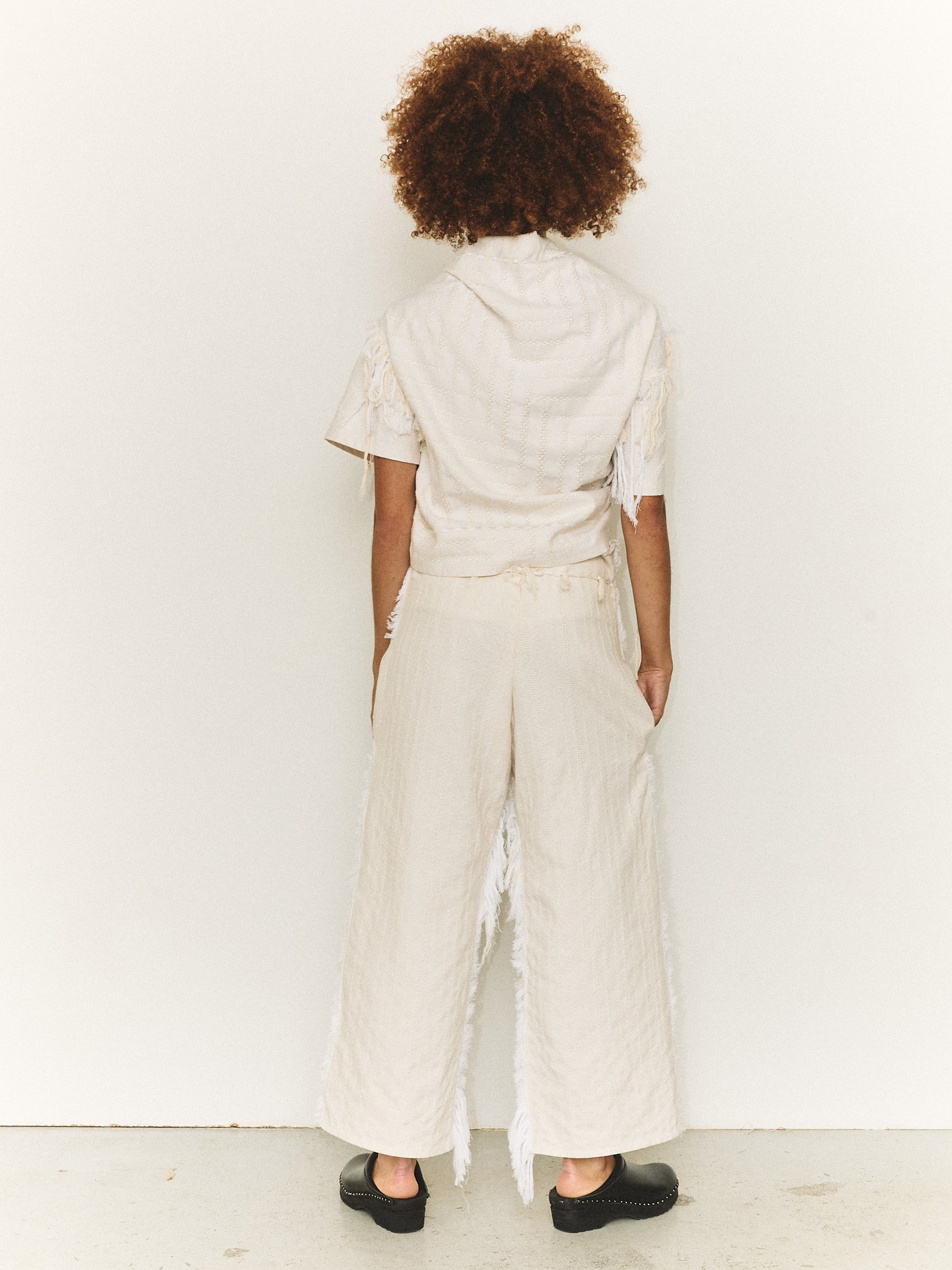 Model wearing the Stem Basket Tee in off-white, back view