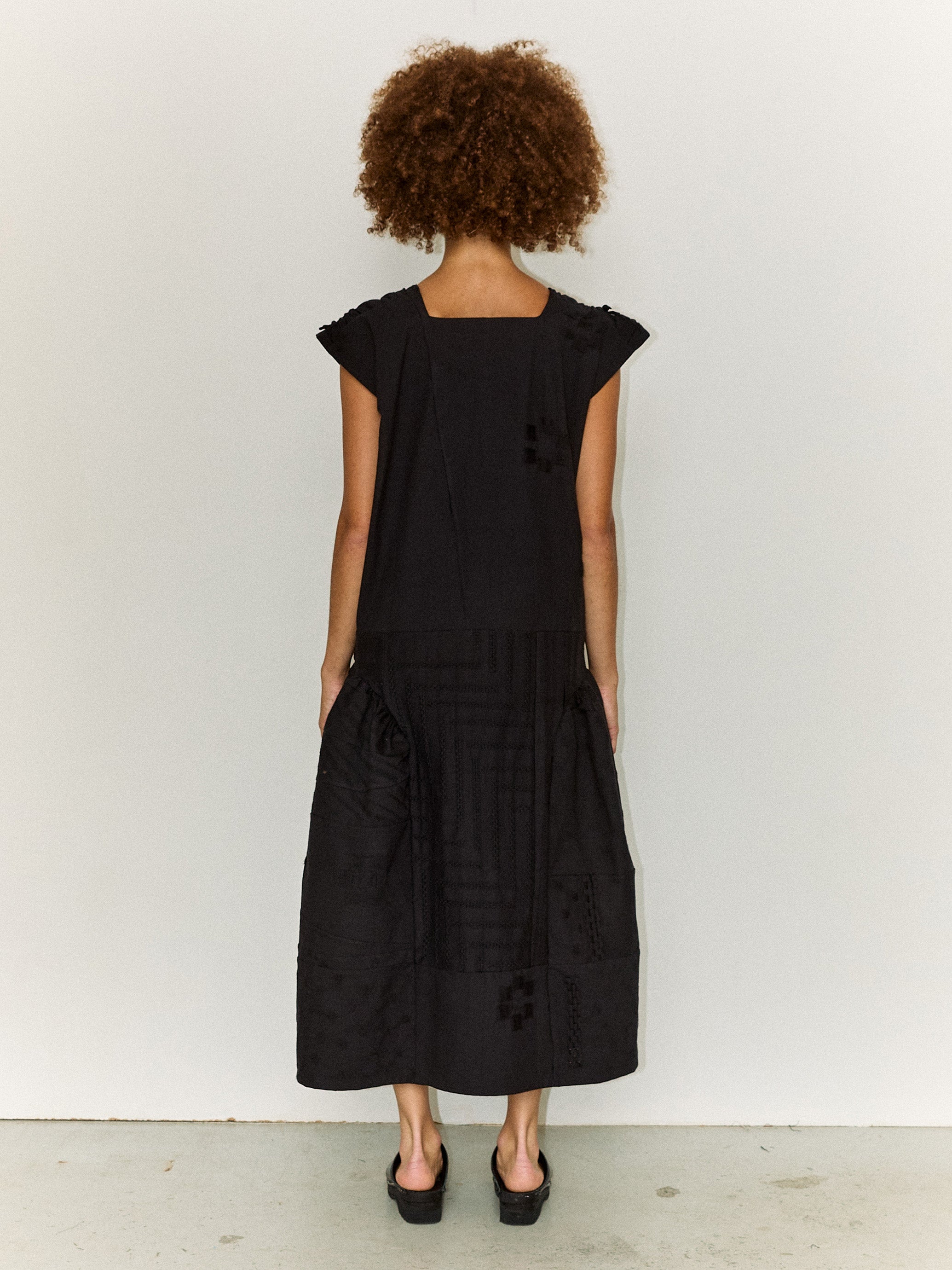 Model wearing the Stem Patchwork Dress in black, back view