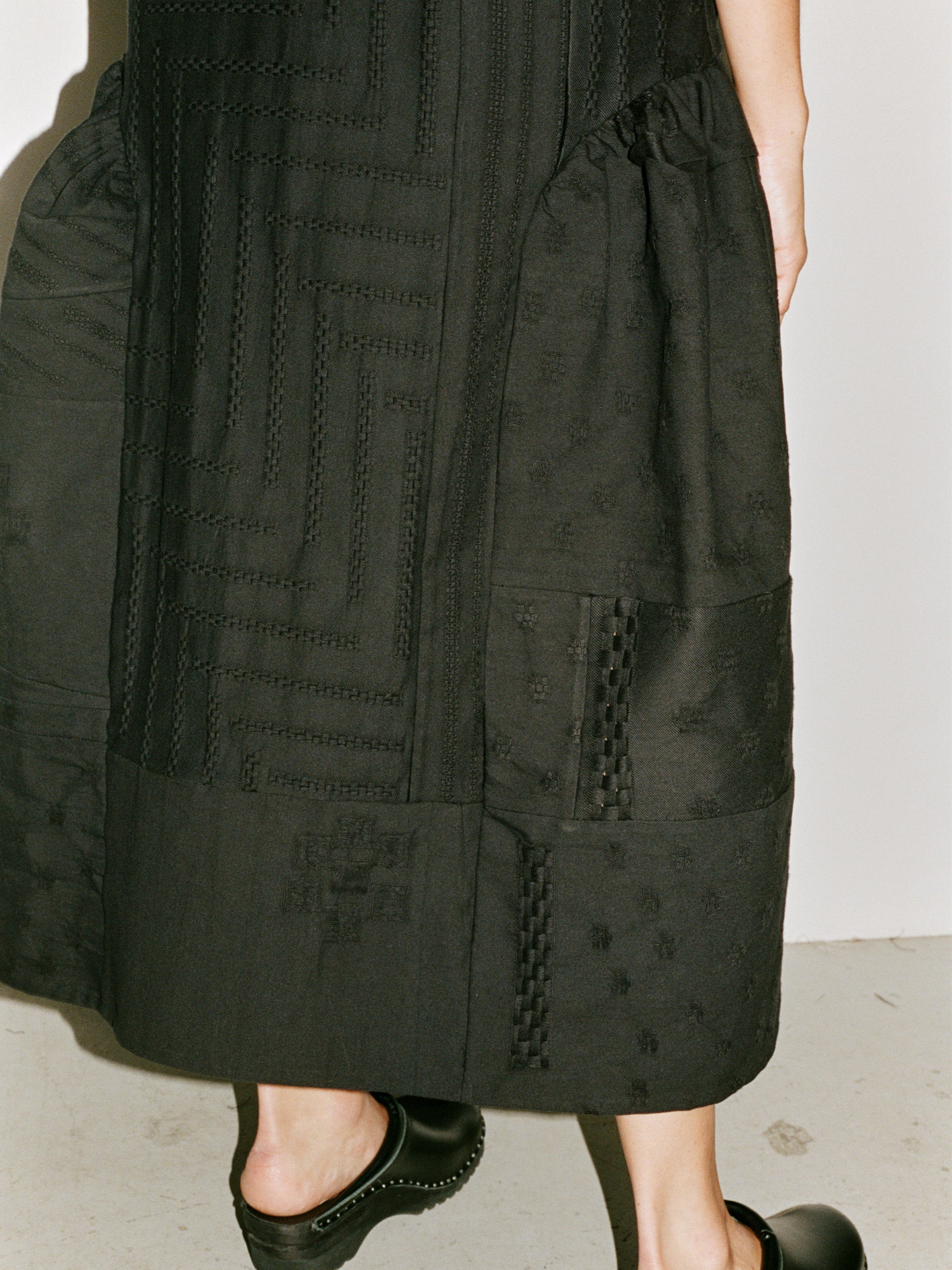 Model wearing the Stem Patchwork Dress in black, close-up of skirt