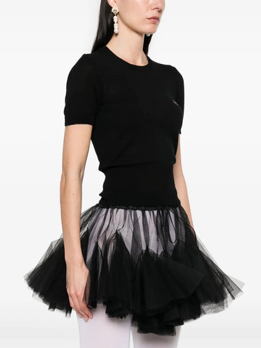 Model wearing Bea Top in Black by Vivienne Westwood, side view showing slim body-skimming silhouette, short sleeves and ribbed hem detail, Spring/Summer 2026