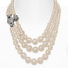 Three row pearl necklace with orb-shaped pendant and clasp on white background.