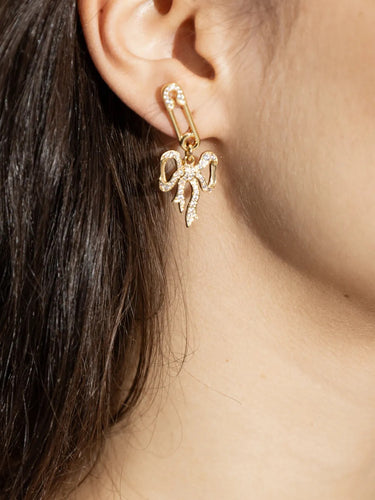 Model wearing Vivienne Westwood Lilith Earring in gold, showcasing pavé safety pin and orb motif with drop silhouette.