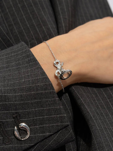Someone wearing the silver bracelet with bow and classic orb charm from Vivienne Westwood on a white background