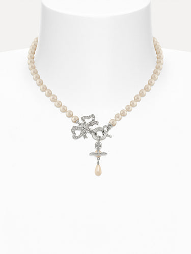Pearl necklace with a silver bow and orb charm on a white background