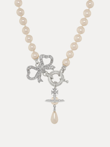 Pearl necklace with a silver bow and orb charm on a white background