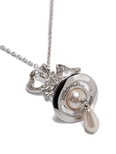 Rigoberta Pearl Pendant by Vivienne Westwood, closeup of crystal-pave bow pendant with signature Orb motif, lustrous cream pearl setting and delicate teardrop pearl drop, silver-tone finish, Spring/Summer 2026