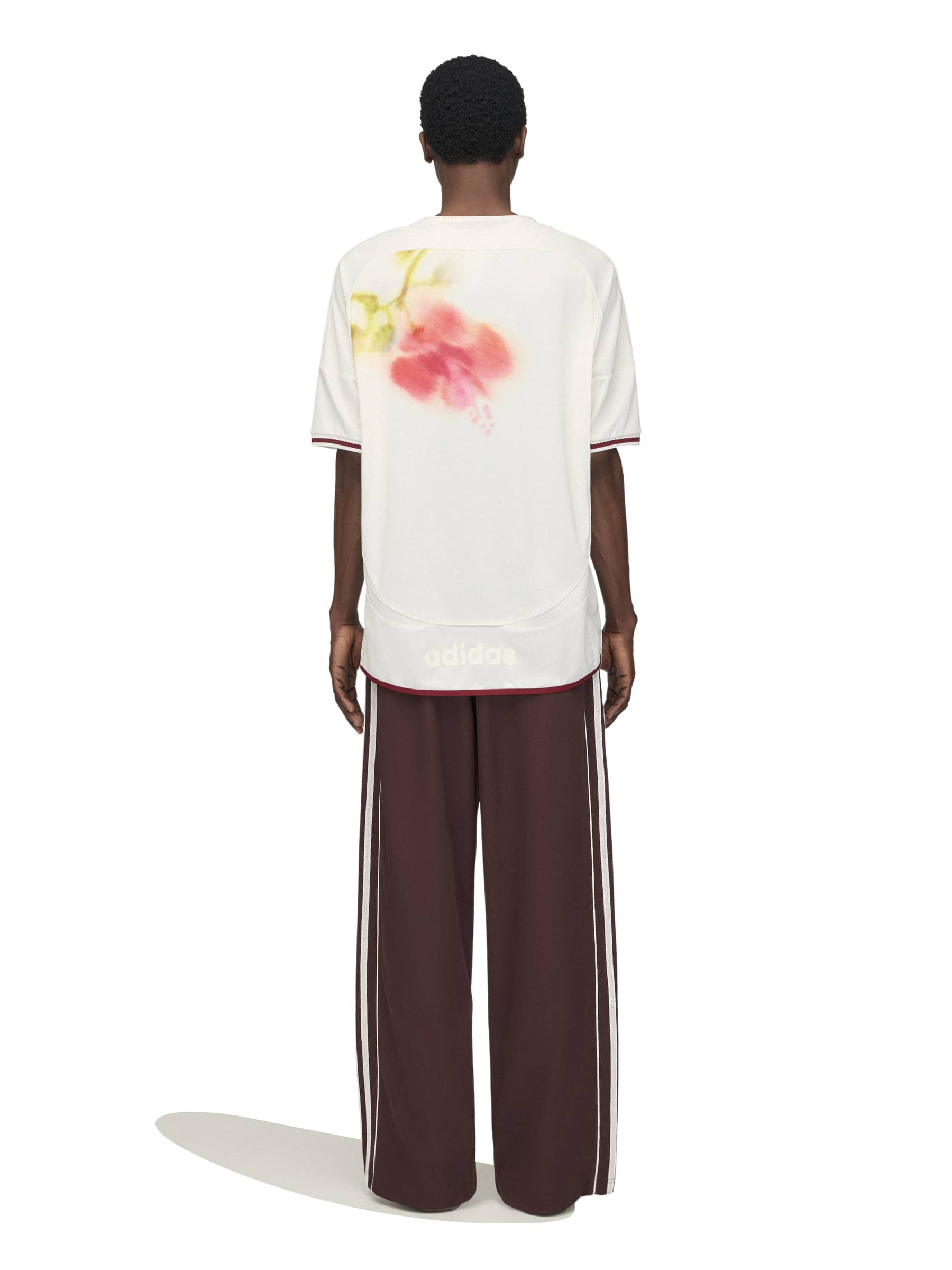 Model wearing the Wales Bonner x Adidas Track Pants in Shadow Brown shadow brown wide-leg track pants with full-length white three-stripe detail, back view – Wales Bonner x Adidas SS26