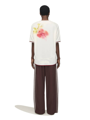 Model wearing the Wales Bonner x Adidas Track Pants in Shadow Brown shadow brown wide-leg track pants with full-length white three-stripe detail, back view – Wales Bonner x Adidas SS26