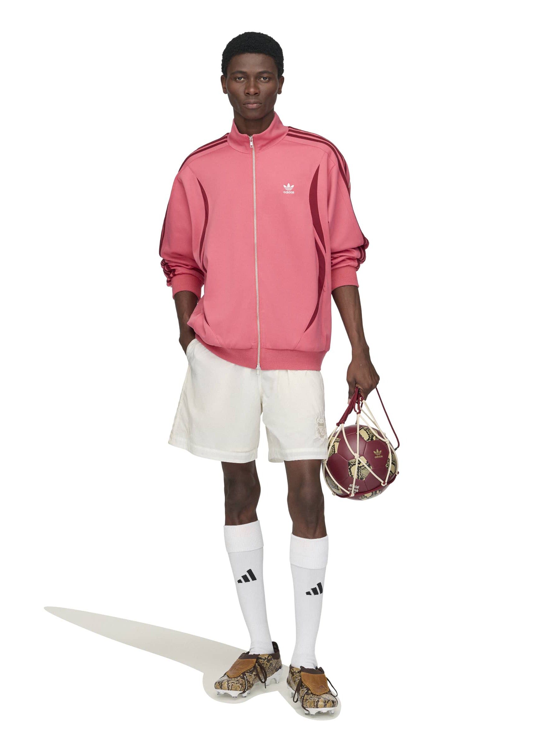 Model wearing the Wales Bonner x Adidas Track Top in Craft Pink pink track jacket with mock neck and burgundy three-stripe detail, front view – Wales Bonner x Adidas SS26