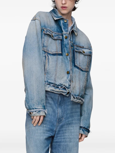 Front view of a female model wearing the Maison Margiela Women’s Sports Jacket in Light Blue Indigo, highlighting the frayed edges, button closure, and relaxed denim fit.
