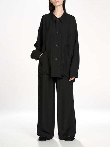 Front view of a female model wearing the Y-3 Chore Jacket Shirt in Black, showing the loose silhouette and versatile design.