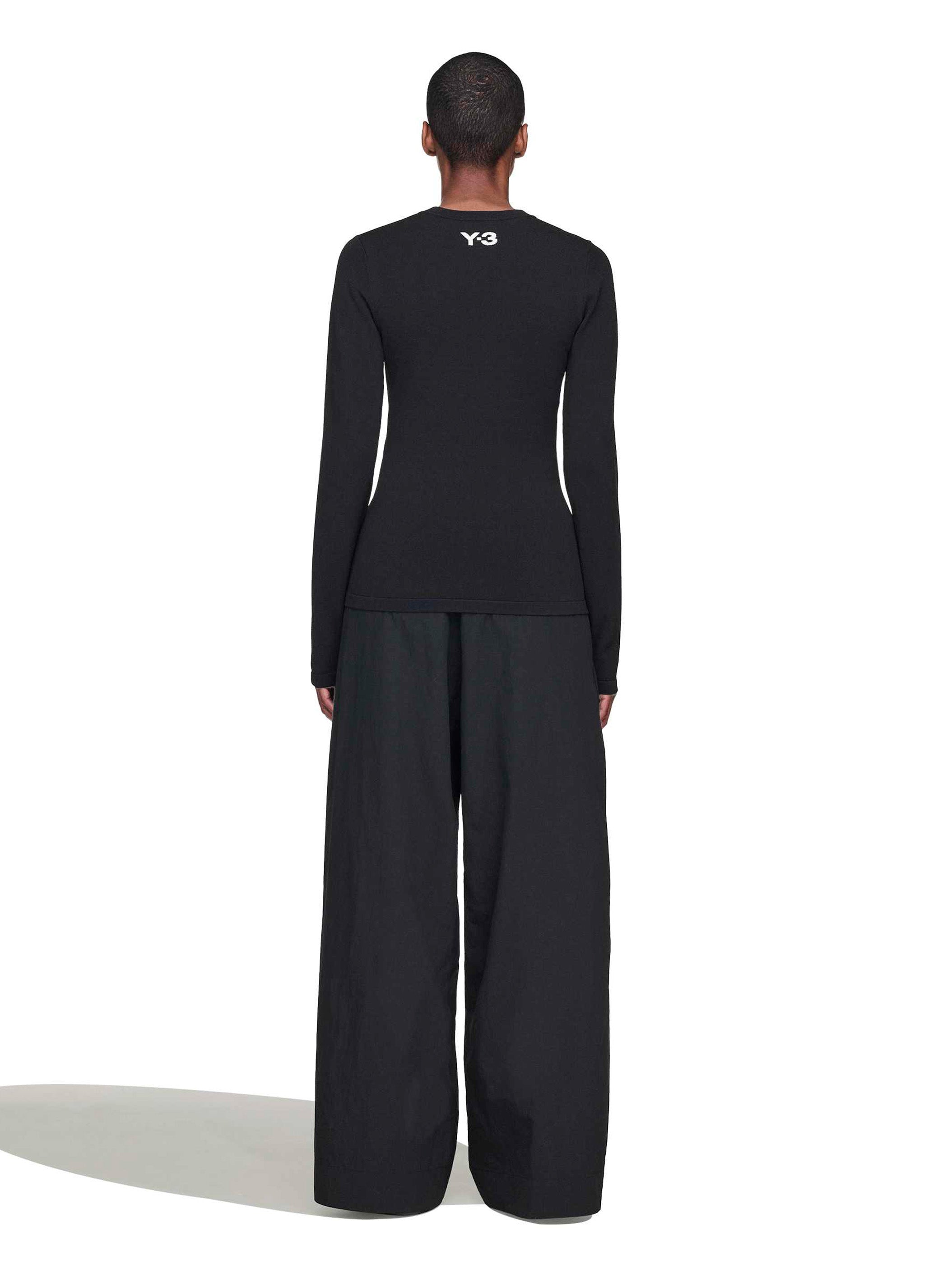 Person wearing a black outfit with a logo on a white background