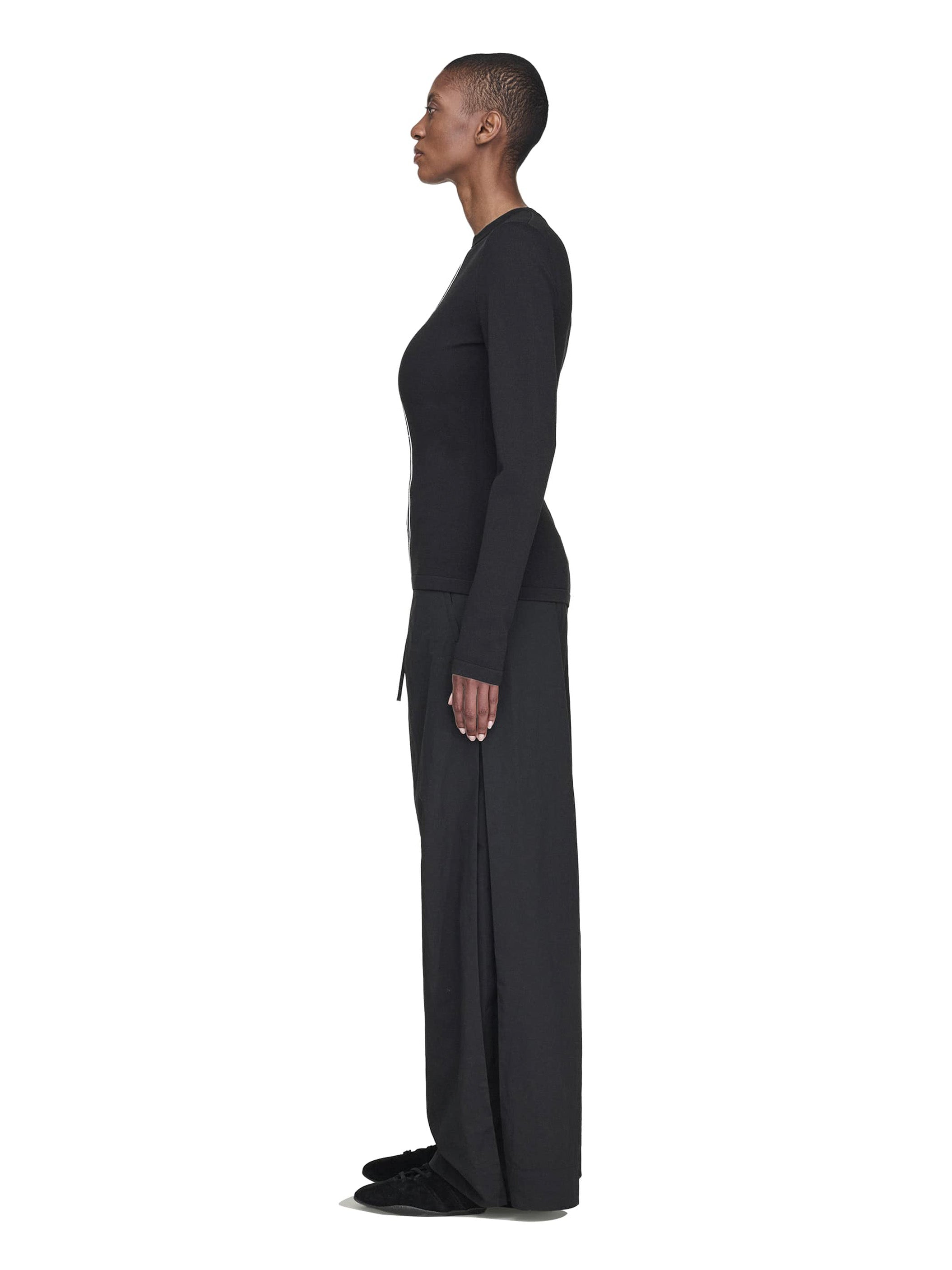 Person wearing a black long-sleeve outfit on a white background