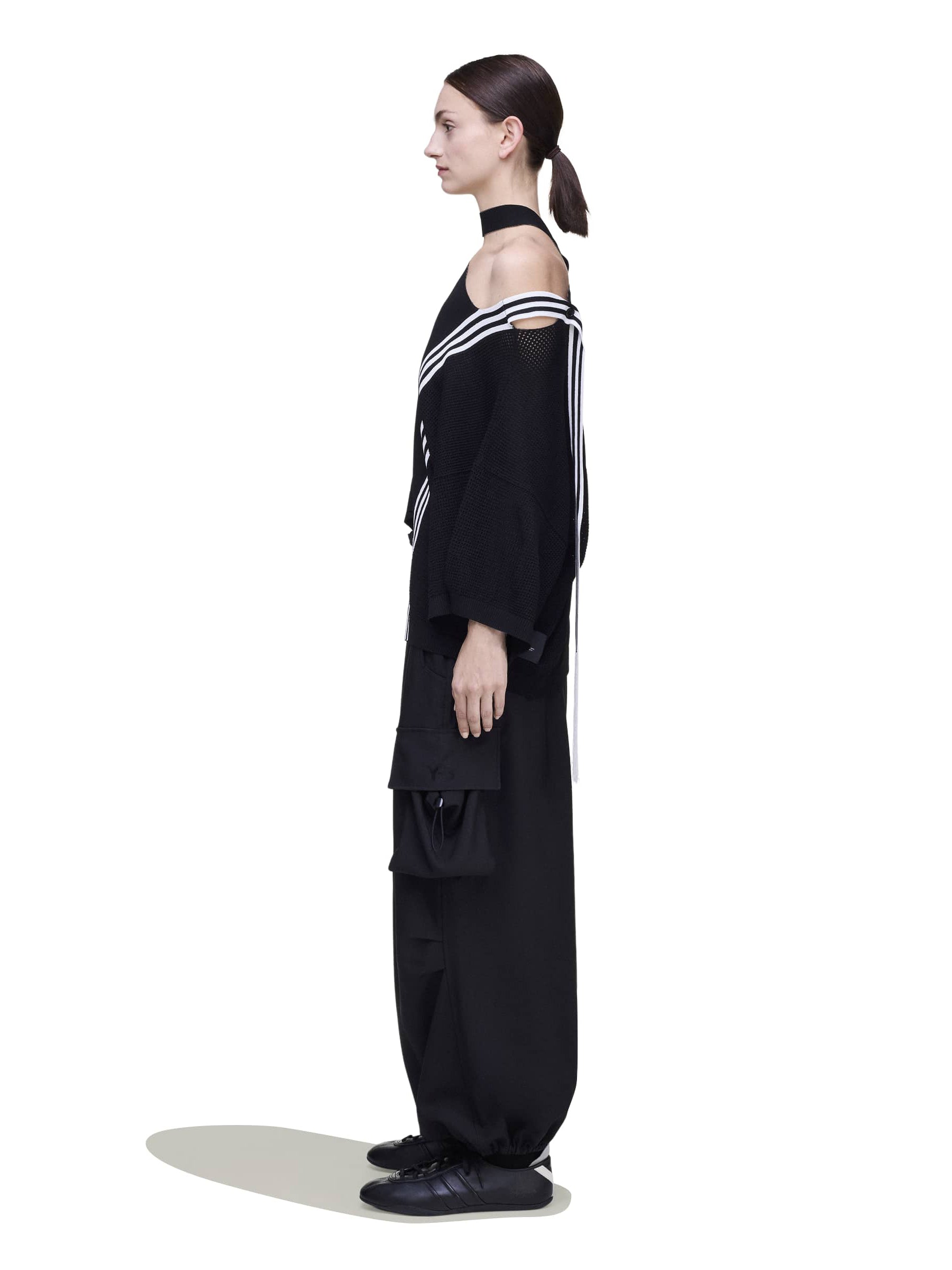 Side view of a female model wearing the Y-3 Knit Top in Black, displaying the drape of the single jersey fabric and relaxed shape.