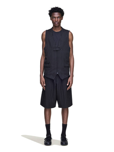 Front view of a male model wearing the Y-3 Pinstripe Sport Uniform Shorts in Black, showing the oversized fit and pinstripe pattern.
