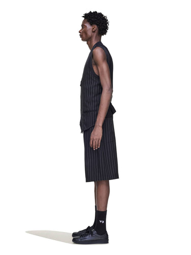 Side view of a male model wearing the Y-3 Pinstripe Sport Uniform Shorts in Black, emphasizing the relaxed silhouette and woven texture.