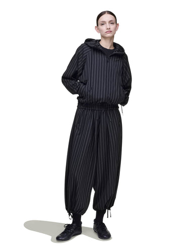 Front view of a female model wearing the Y-3 Raw-Cut Wool Pants in Black, showing the cropped wide-leg silhouette and raw-cut hem.