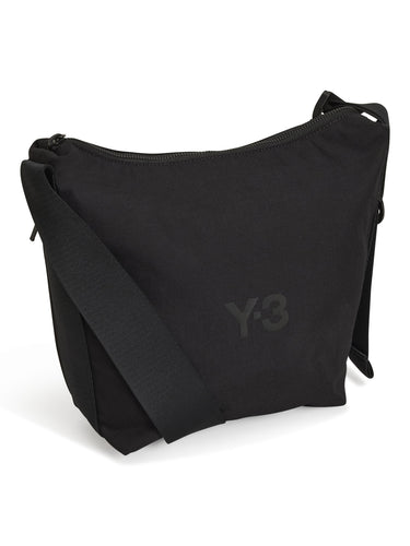 Side view packshot of the Y-3 Small Crossbody Bag in Black, emphasizing the compact shape and adjustable strap.