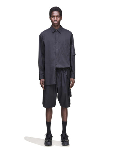 Front view of a male model wearing the Y-3 Sport Uniform Cargo Shorts in Black, showing the oversized fit and utilitarian-inspired design.