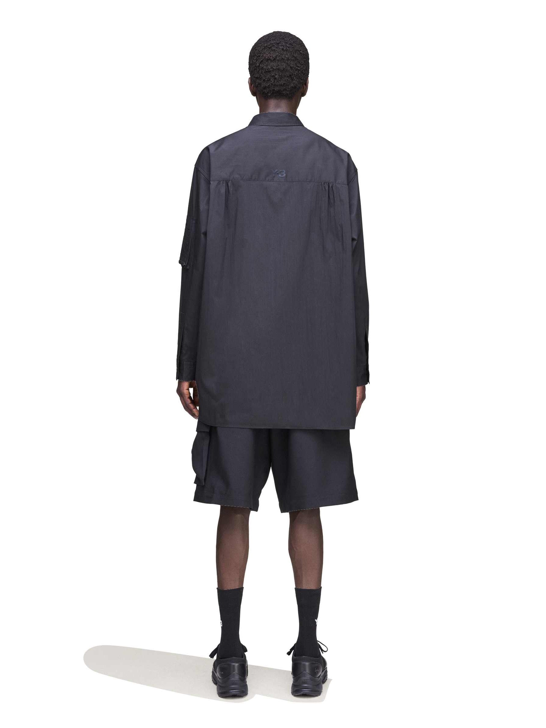 Back view of a male model wearing the Y-3 Sport Uniform Cargo Shorts in Black, highlighting the relaxed fit and functional design.