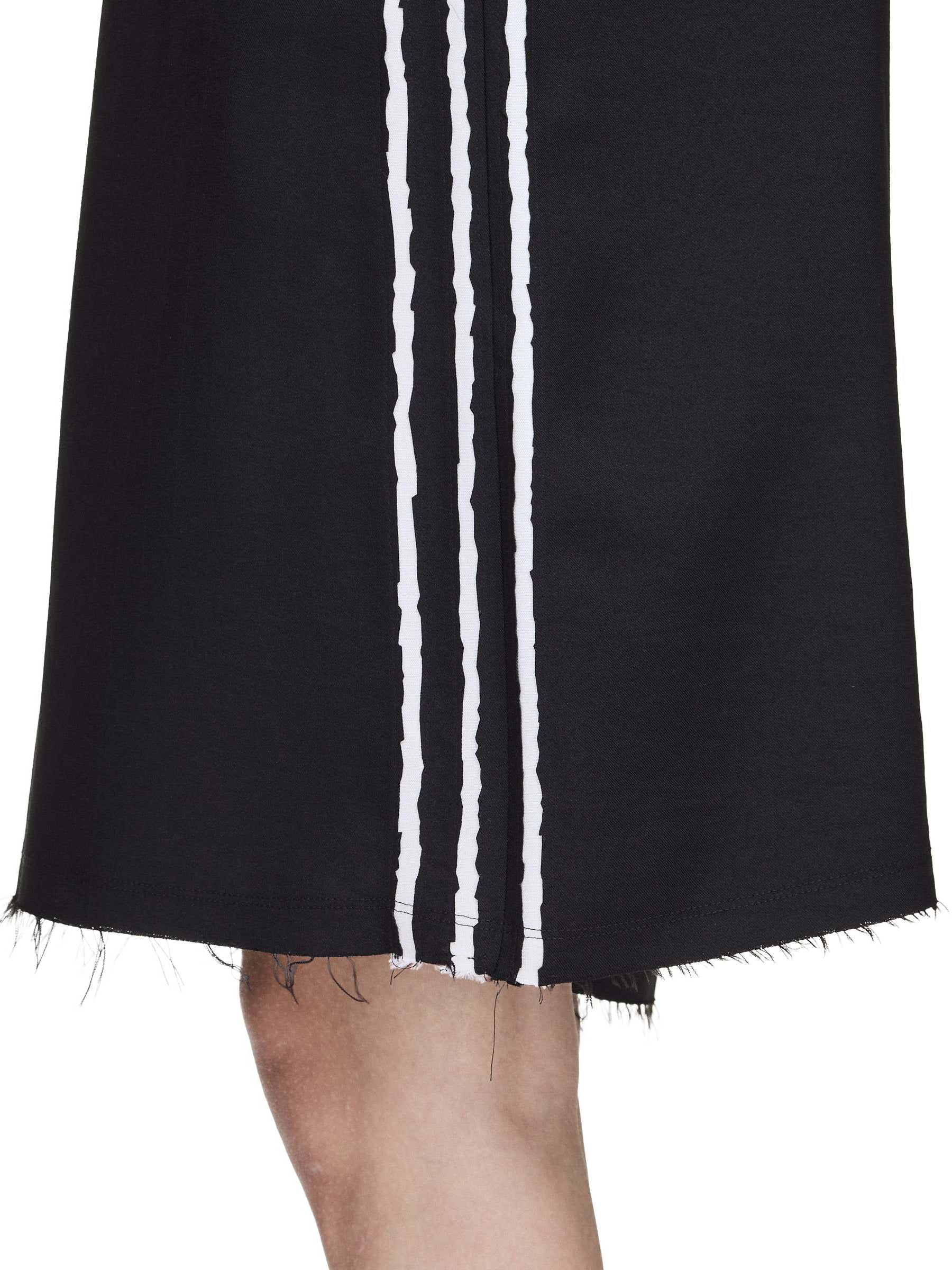 Side close-up of the Y-3 Summer Run 3-Stripes Shorts on a female model, focusing on the raw-cut 3-Stripes and twill texture.
