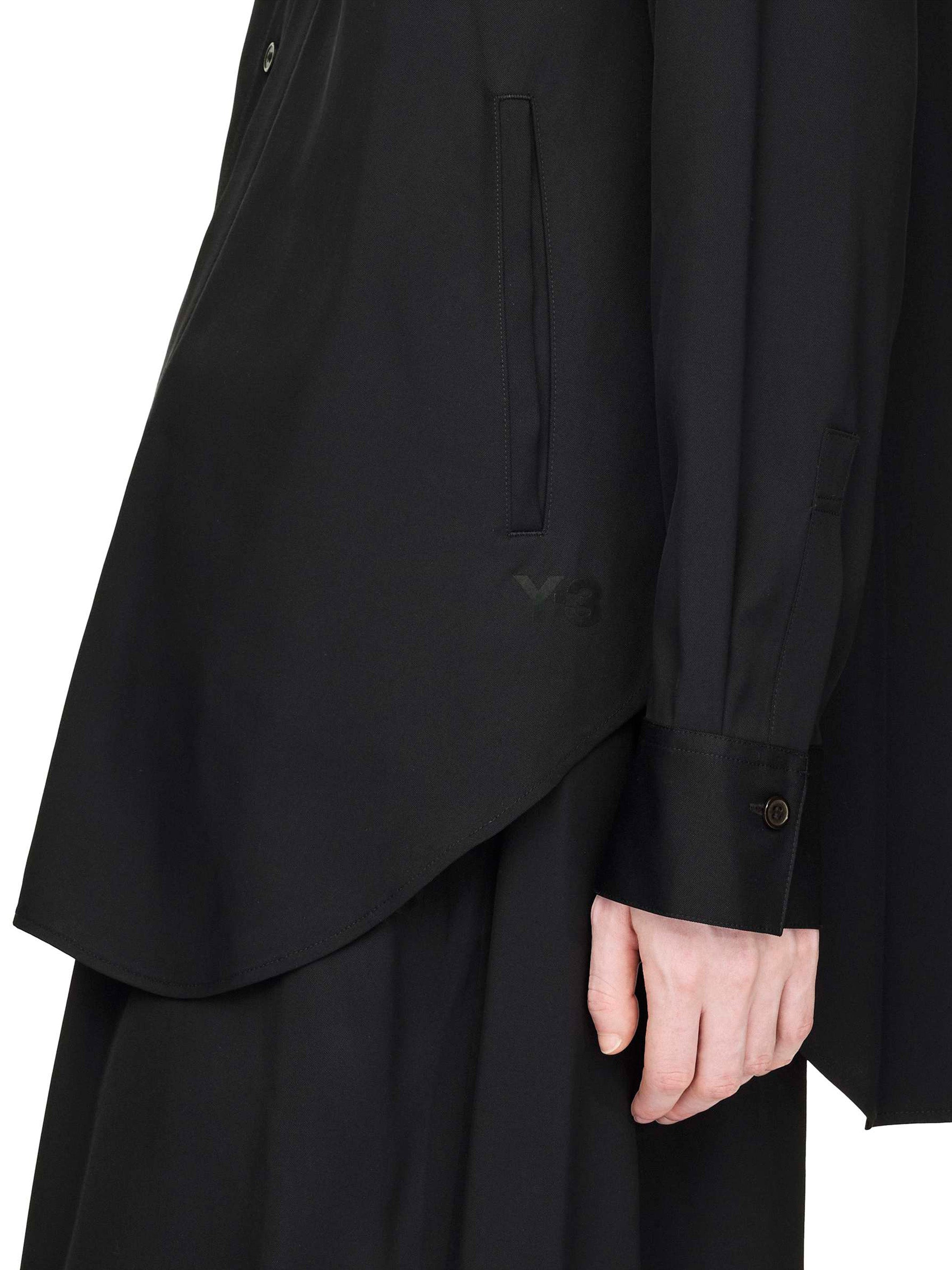 Black layered garment with a hand visible on a white background